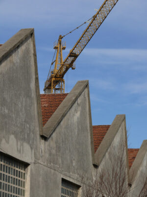 Industrial archeology buildings in the city of Busto Arsizio. Facade of ancient factory shed. Construction crane. Foto Busto Arsizio photo