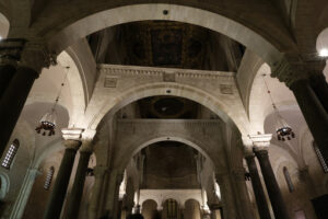 Interior of the Basilica of San Nicola in Bari. Arches, columns, capitals and limestone walls. Foto Bari photo.