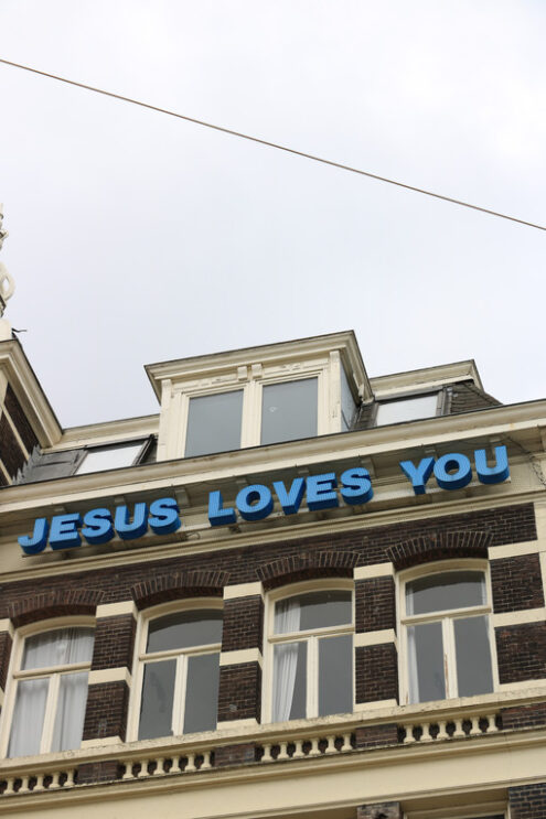 It teaches “Jesus loves you” on the facade of a building. - MyVideoimage.com