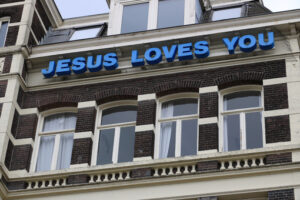 It teaches “Jesus loves you” on the facade of a building. - MyVideoimage.com