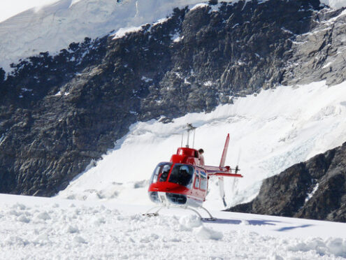 Jungfrau, Switzerlan. Red helicopter on high mountain snow - MyVideoimage.com