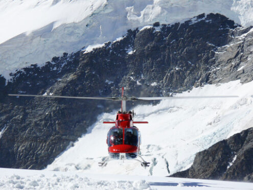 Jungfrau, Switzerlan. Red helicopter on high mountain snow - MyVideoimage.com