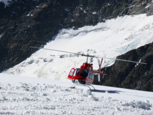 Jungfrau, Switzerland. Red helicopter on high mountain snow - MyVideoimage.com