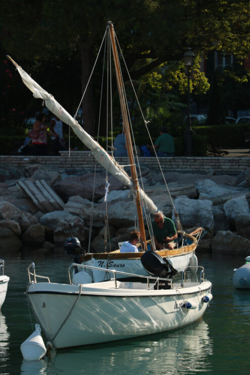 Lerici harbor. Colorful fishing boats moored at the harbor. Two fishermen are preparing to set sail. - MyVideoimage.com | Foto stock & Video footage