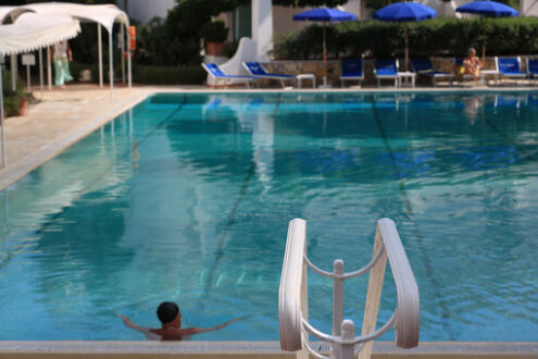 Man in the pool with green water. In the foreground, a white han - MyVideoimage.com