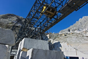 Marble deposit with overhead crane. Apuan Alps, Carrara, Tuscany, Italy. March 28, 2019. An overhead crane in a white marble quarry. Cave marmo. - MyVideoimage.com | Foto stock & Video footage