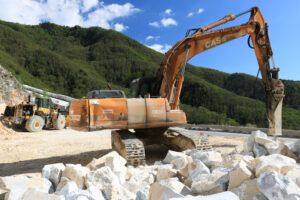 Marble excavator. Excavator with demolition hammer in a Carrara marble quarry. - MyVideoimage.com | Foto stock & Video footage