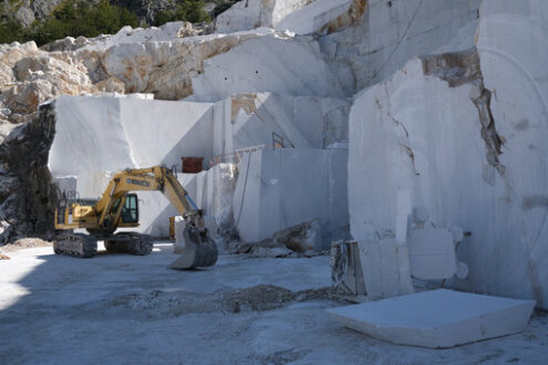 Marble wall with excavator in a quarry. Crawler excavator in a marble quarry near Carrara. Stock photos. - MyVideoimage.com | Foto stock & Video footage