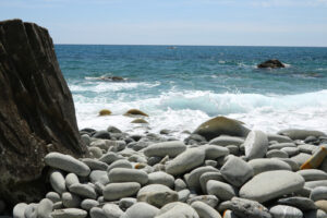 Mare Cinque Terre. Beach with large stones near the Cinque Terre. Velvety sea with long exposure. Scoglio del Ferale, La Spezia. - MyVideoimage.com | Foto stock & Video footage