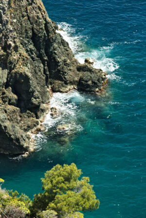 Mare delle Cinque Terre. Sea waves break on the rocks of the Ligurian mountain.  Near the Cinque Terre a seascape with blue sea and dark red rocks. Village of Framura. - MyVideoimage.com | Foto stock & Video footage