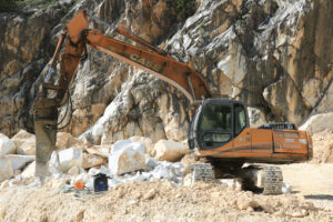 Martello demolitore in cava di marmo. Excavator with demolition hammer in a Carrara marble quarry. - MyVideoimage.com | Foto stock & Video footage