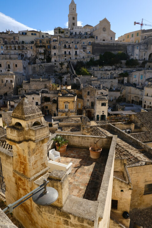 Matera Hotel in the Sassi. Roofs of houses in the Sassi of Matera transformed into hotels. Panoramic terrace with sofa and chair in white plastic. - MyVideoimage.com | Foto stock & Video footage