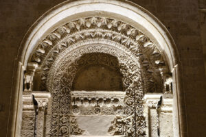 Matera by night. Night photo of the facade of the church of San Giovanni in Matera. Photographed with artificial lights. Detail of the portal in Arabic style. - MyVideoimage.com | Foto stock & Video footage