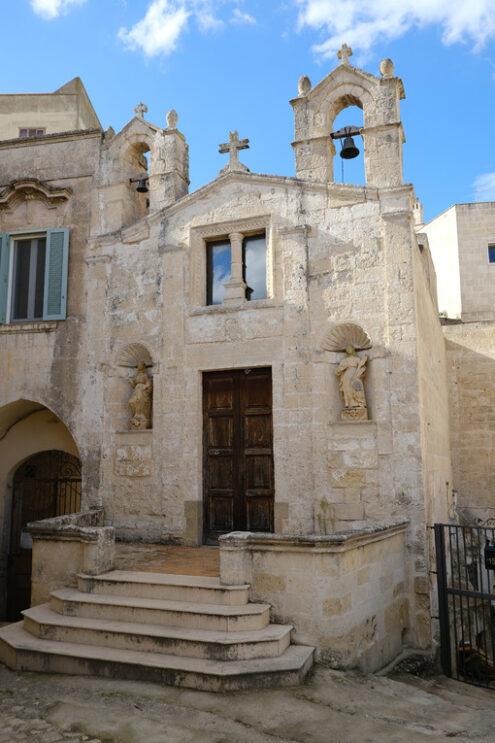 Matera church of San Biagio. Church of San Biagio in Matera located in the Foggiali area. The construction is made of blocks of tufa stone of beige color. Facade with two small bells. - MyVideoimage.com | Foto stock & Video footage