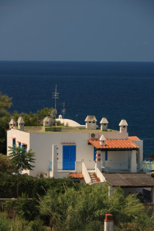 Mediterranean style holiday home with white walls and fireplaces. Sea and blue sky background. - MyVideoimage.com