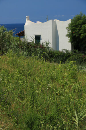 Mediterranean style holiday home with white walls and fireplaces. Sea and blue sky background. - MyVideoimage.com