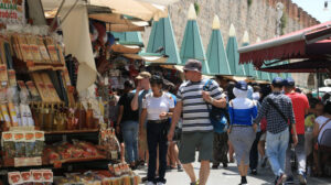 Mercato turistico a Pisa. Un Turista acquista souvenir che ricordano Piazza dei Miracoli e la Toscana. - MyVideoimage.com | Foto stock & Video footage