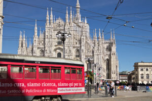 Milan Cathedral. Piazza del Duomo in Milan with people and trams. People walking and a yellow tram. - MyVideoimage.com | Foto stock & Video footage