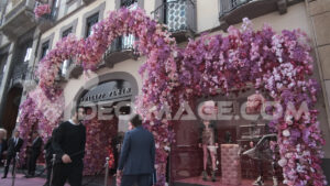 Milan fashion shop video. Facade of the shop with a large bush of rose-colored artificial roses.  Video footage.