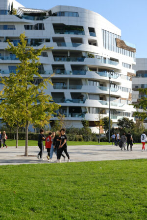 Milan houses. CityLife Milan Residential Complex. Palaces designed by Zaha Hadid. People stroll in the green gardens. - MyVideoimage.com | Foto stock & Video footage