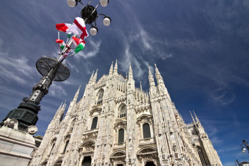 Milano Duomo. La facciata del Duomo di Milano. Bandiere che sventolano sul cielo blu. - MyVideoimage.com | Foto stock & Video footage