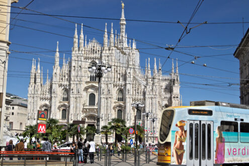 Milano tram in Piazza Duomo. Piazza del Duomo in Milan with people and trams. The facade of the cathedral. In the foreground people walking and a multicolor tram. - MyVideoimage.com | Foto stock & Video footage