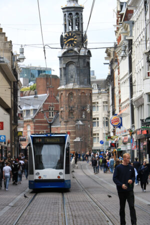 Modern tram in the center of Amsterdam, front view with the tower. Amsterdam foto. Amsterdam photo