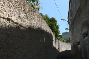 Narrow pedestrian street with white painted wall in southern Italy. Ischia island . Foto Ischia photos.