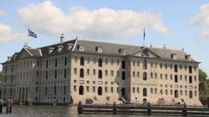 National Maritime Museum of Amsterdam and a tourist wooden boat. - MyVideoimage.com