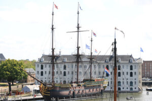 National Maritime Museum of Amsterdam and a tourist wooden boat. Amsterdam foto. Amsterdam photo