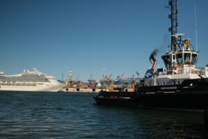 Nave Costa al porto di La Spezia. Cruise ship Costa Fortuna anchored at the Port of La Spezia in Liguria. Sky and blue sea background. In the foreground some tugs. - MyVideoimage.com | Foto stock & Video footage