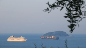 Nave da crociera Crystal Serenity. Crystal Serenity cruise ship and container ship with olive leaves. The Gulf in the Mediterranean Sea with Islands in the background light of dawn. - MyVideoimage.com | Foto stock & Video footage