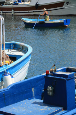 Old woman in a boat. Woman with rowing boat in the port of Corricella. - MyVideoimage.com | Foto stock & Video footage