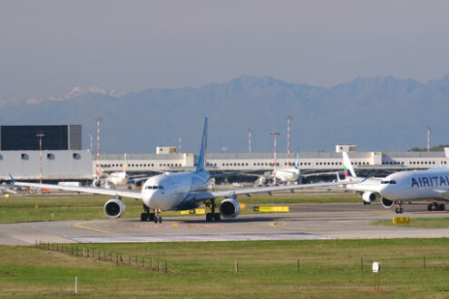 Oman Air Airbus A330-243  airplane on the Malpensa airport runway. In the background the buildings and Air Italy airplane. - MyVideoimage.com