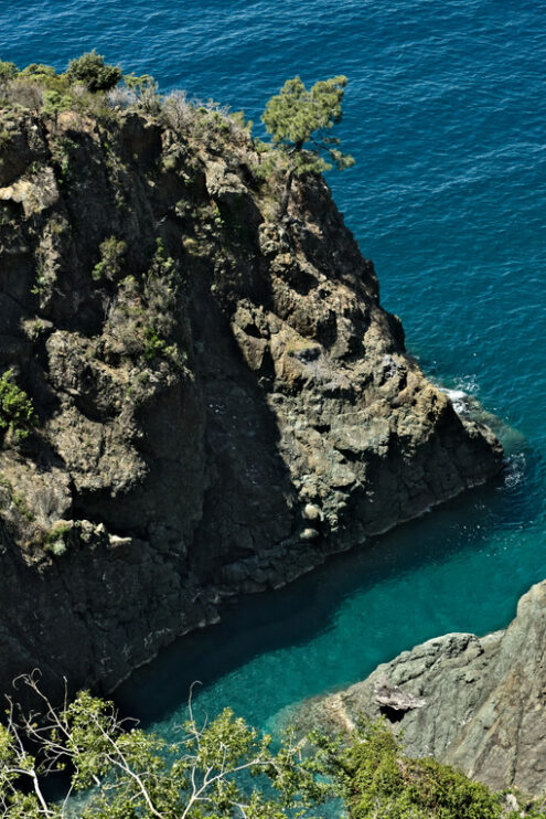 Onde sulle rocce della Liguria. Sea waves break on the rocks of the Ligurian mountain.  Near the Cinque Terre a seascape with blue sea and dark red rocks. Village of Framura. - MyVideoimage.com | Foto stock & Video footage