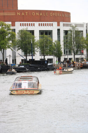 Opera house with marble and brick façade overlooking the Amstel canal. In the foreground a boat. - MyVideoimage.com