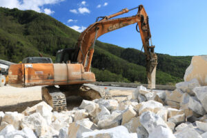 Pala meccanica in cava di marmo. Excavator with demolition hammer in a Carrara marble quarry. - MyVideoimage.com | Foto stock & Video footage