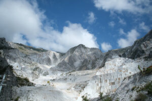 Panorama cave di marmo. Panorama of a white Carrara marble quarry in Tuscany. Mountains of the Apuan Alps, blue sky and cloud. - MyVideoimage.com | Foto stock & Video footage