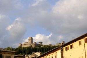 Panorama of the Rocca Maggiore castle in Assisi. 	The fortress illuminated at sunset immersed in a cypress wood. - MyVideoimage.com