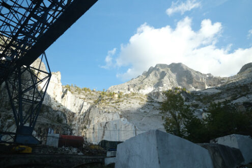 Marble quarry in Carrara. Panoramic view of the Apuan Alps from a quarry of white Carrara marble. A large overhead crane used to move marble blocks.