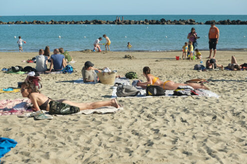 People lying in the sun. People lying on the beach of a village in Liguria. Stock photos. - MyVideoimage.com | Foto stock & Video footage