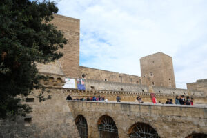 People walking on the bridge of the Swabian castle of Bari. The fort is built entirely with stone walls. - MyVideoimage.com