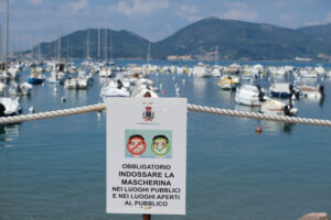 Period of Covid 19, warning signs with the sea in the background and the inscription. - MyVideoimage.com | Foto stock & Video footage