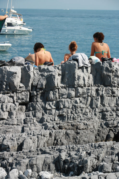 Persone al sole. Persone distese prendere il sole sulle scogliere dell’isola Tino, nel golfo di La Spezia. - MyVideoimage.com | Foto stock & Video footage