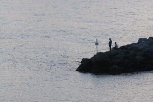 Pesca in mare. Pescatori con canna da pesca sulle rocce a La Spezia. - MyVideoimage.com | Foto stock & Video footage