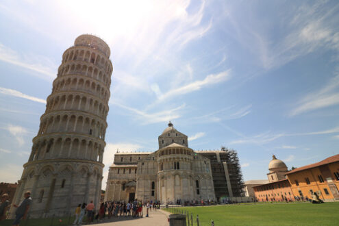 Pisa Tuscany, Piazza dei Miracoli. Piazza dei miracoli of Pisa. Travelers admire architecture. Cathedral, leaning tower of the Tuscan city. Blue sky with clouds. - MyVideoimage.com | Foto stock & Video footage