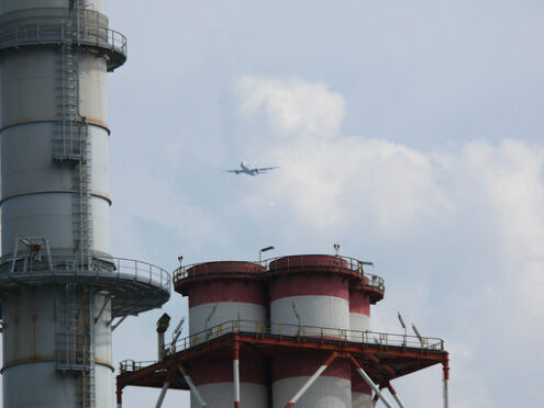 Plane flies over the chimneys of a power plant - MyVideoimage.com