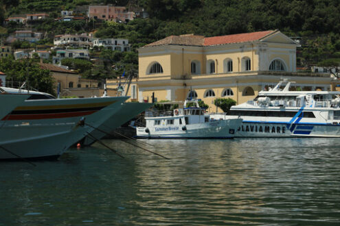 Port of Ischia created in the crater of an ancient volcano. In the background the church and a few anchored boats. - MyVideoimage.com