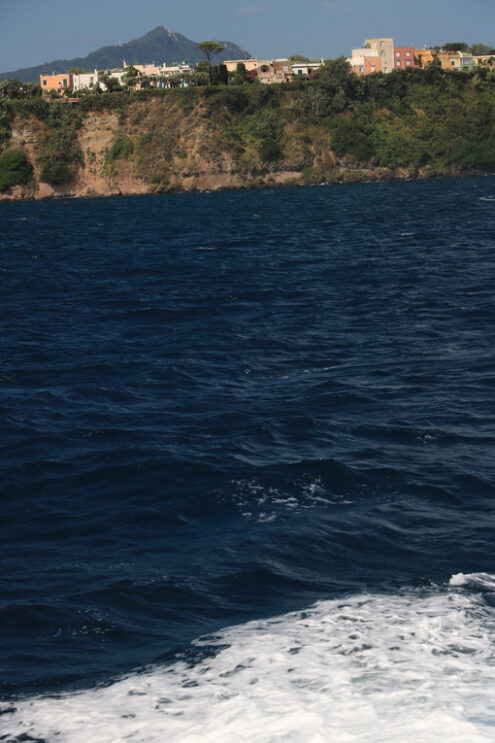 Procida island from the sea. The island of Procida seen from the sea. The village with colorful houses and the ancient castle on the mountain. - MyVideoimage.com | Foto stock & Video footage