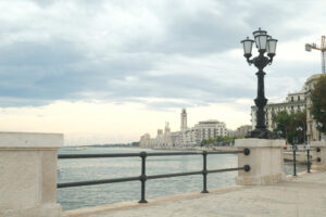 Promenade of Bari with the buildings of the Murattiano village. A parapet and a street lamp on the road that runs along the sea. - MyVideoimage.com | Foto stock & Video footage